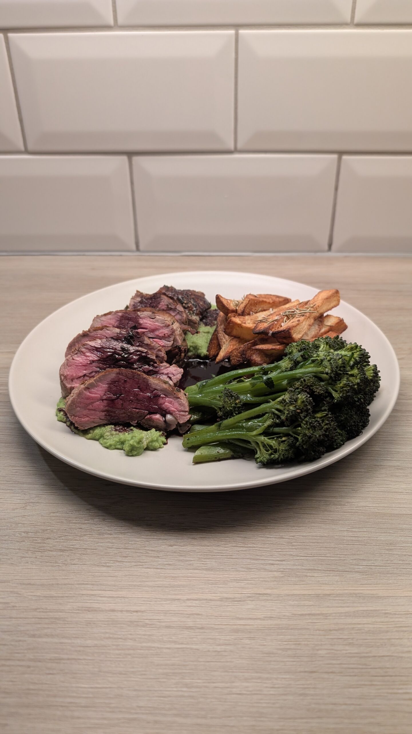 Fillet Steak on a Pea Puree Finished with a Red Wine Jus, Rosemary Chips and Garlic Purple Sprouting Broccoli