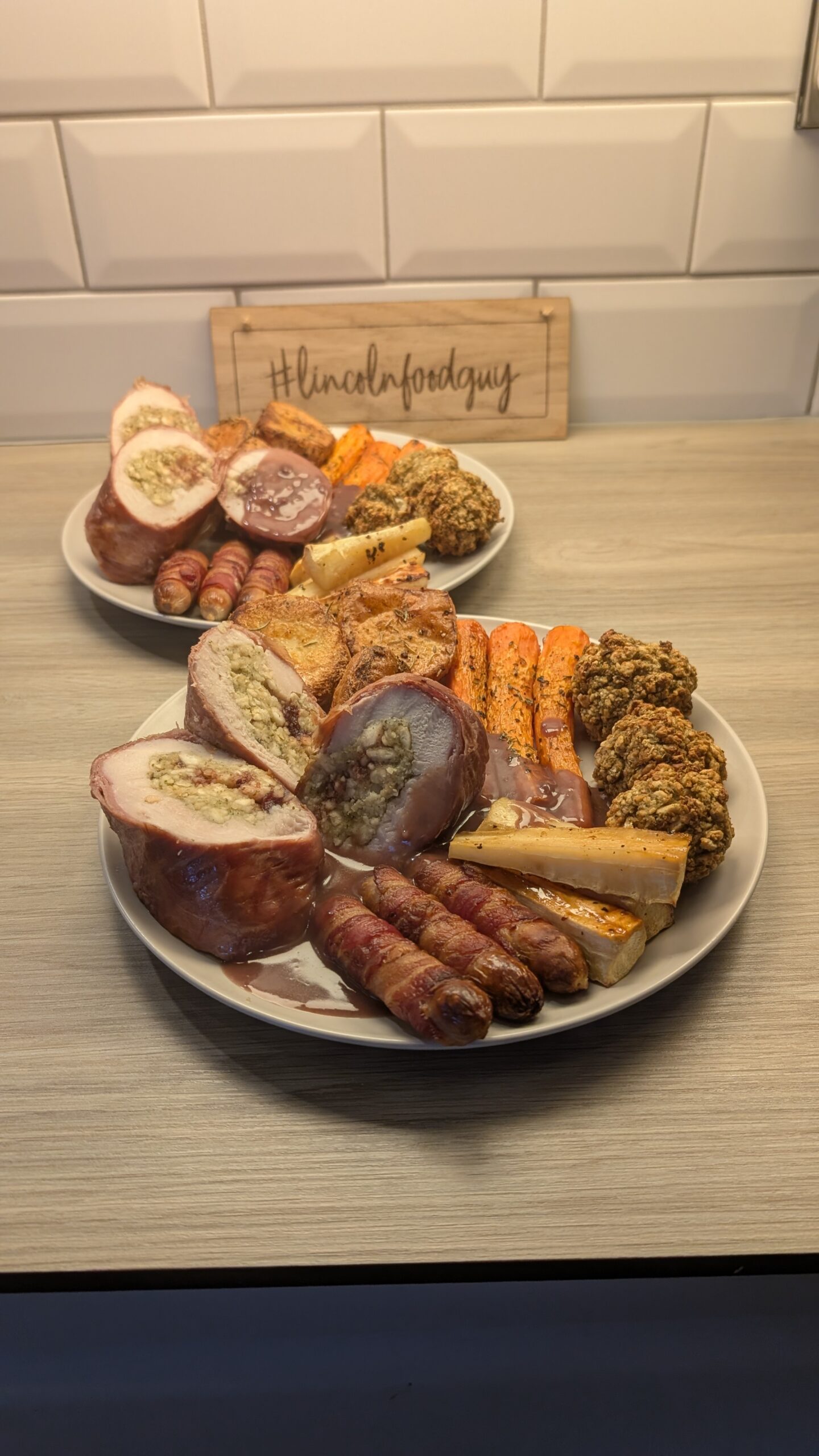 Turkey, Stuffing and Cranberry Ballotine Wrapped in Prosciutto, Rosemary Roast Potatoes, Honey Glazed Parsnips, Roasted Carrots, Pigs in Blankets and Stuffing with a Red Wine Gravy
