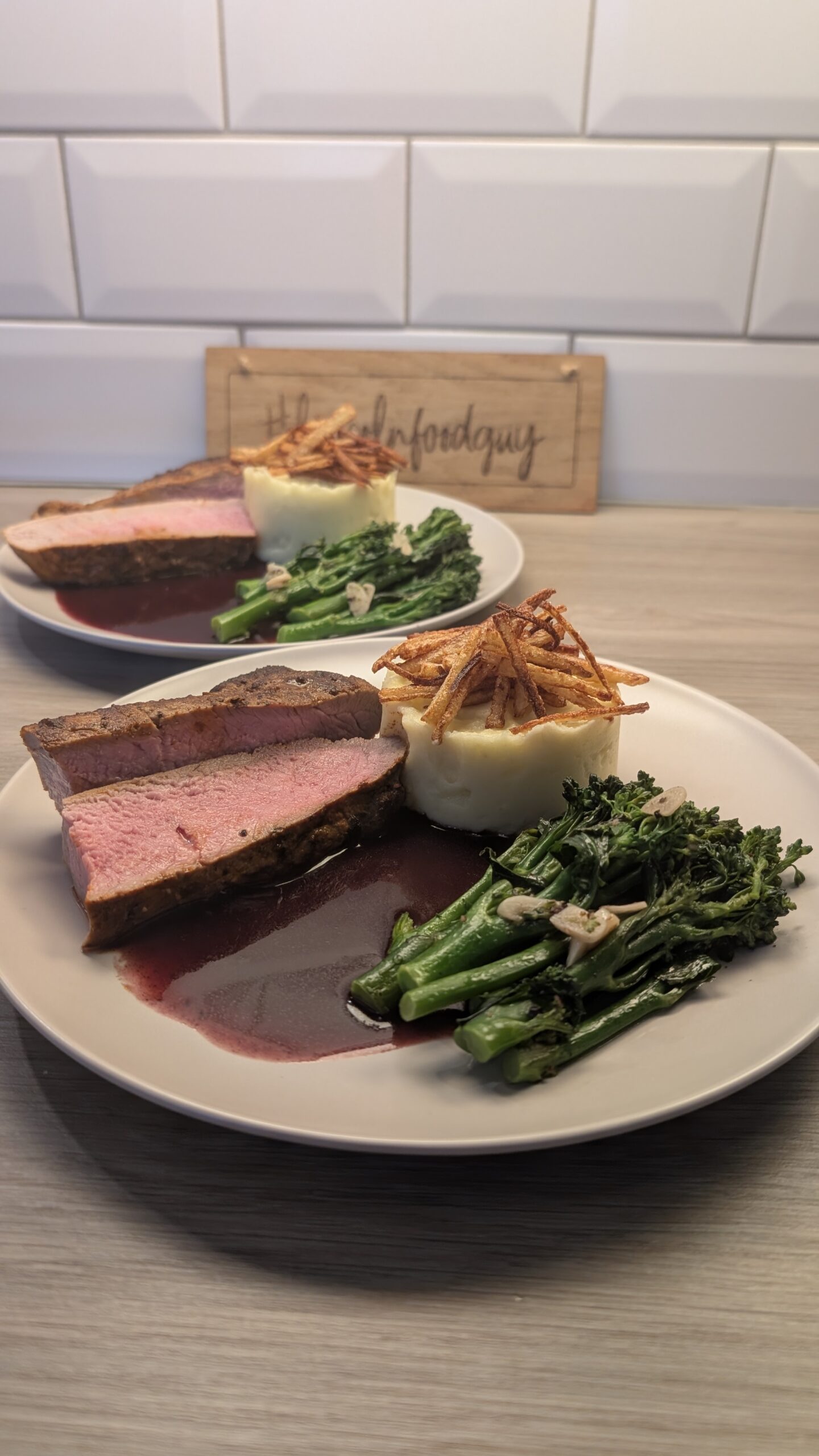 Medium Rare Pork Fillet Cooked in Paprika Butter, Mash Potatoes Topped with Crispy Potatoes and Garlic Tenderstem Broccoli with a Red Wine Reduction